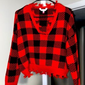 Medium sized, red & black checkered sweater, with fringed waist and wrists.